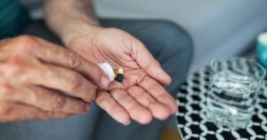 Antidepressant Taken by Millions Recalled Over Possible Contamination With Cancer-causing Chemical A senior man, feeling stressed and depressed, takes a pill with a glass of water. Depicting the act of self-medication and the impact of antidepressant drugs, use of medicines