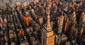 NYC Is Literally Sinking — And the Price Tag Could Hit $18 Billion Sunset Aerial View of Empire State Building Spire and a Top Deck Tourist Observatory. New York City Business Center From Above. Helicopter Photo of an Architectural Wonder in Midtown Manhattan