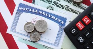 American US dollars money bills, social security number card and calculator on American flag