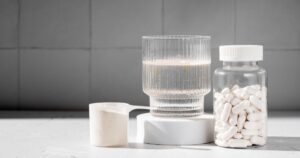 Common Supplement May Help Reduce Alzheimer's Disease Risk, Study Shows Food supplement concept. Capsules of probiotics, vitamins, white pills and a scoop of protein collagen powder.