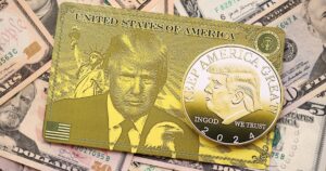 Trump gold card and souvenir coin on big amount of US dollar money bills banknotes close up