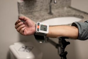 Your Blood Pressure Reading Hides a Third Number That Could Predict Dementia Close-up of an arm using a wrist sphygmomanometer in a healthcare setting.
