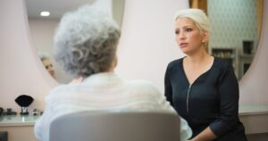 10 Casual Phrases That May Reveal Someone's Narcissistic Tendencies Two women having a conversation in a salon setting with a mirror reflecting their interaction.