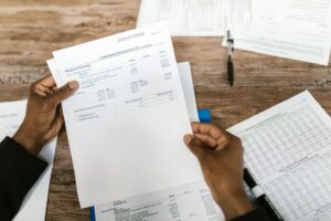 Experts Warn Elon Musk's SpaceX IPO Is Coming Straight for Your 401(k) Hands holding financial papers for tax preparation and analysis.