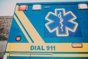 Stroke Signs and Symptoms: What to Look For and How to BE FAST Close-up of an ambulance with star of life symbol and 'Dial 911' text.