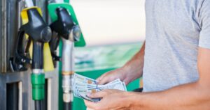 Man counting American money at a gas station