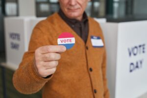New Poll Results Could Be Creating Serious Problems for Trump A senior adult holding a vote sticker inside a polling booth during election day.