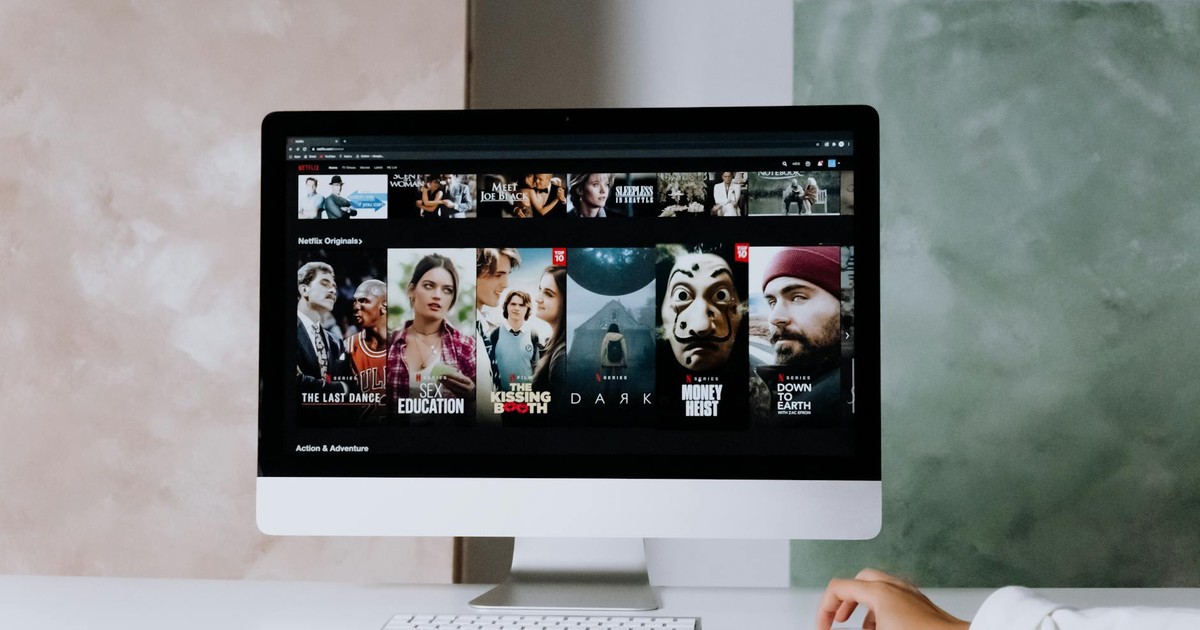 A modern workspace featuring a desktop screen displaying popular streaming series on Netflix.