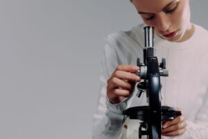 A scientist carefully examining samples using a microscope in a modern laboratory setting.