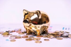 The Retirement Accounts Most Americans Don't Know They Need in 2026 Shiny golden piggy bank on financial documents with scattered coins symbolizes savings.