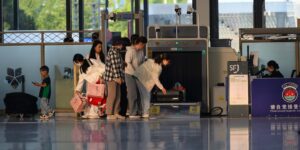 Don't Have Real ID Yet? This TSA Rule Could Hit Your Bank Account Travelers undergo security screening at an airport terminal.