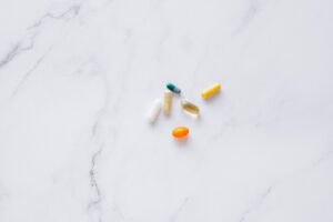 A variety of colorful pills arranged on a white marble surface, representing healthcare.