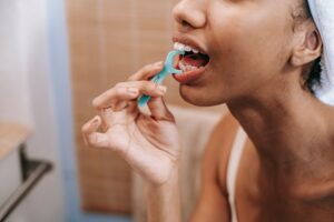 Harvard Research Reveals the Everyday Habit That May Be Quietly Cutting Your Life Short Crop ethnic female doing oral procedure with dental flosser in morning at home