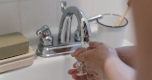 10 Everyday Things You Should Wash Your Hands After Touching Hands washing under a faucet with running water, emphasizing hygiene and cleanliness.