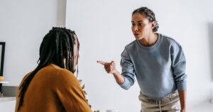 11 Basic Needs Every Wife Deserves in a Healthy Marriage Young African American female standing near table while male sitting at kitchen and having argument