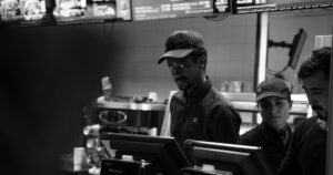 16 McDonald's Employee Secrets They Don't Want You To Know Black and white image of fast food employees behind the counter in Oslo, Norway.