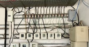 Complex network of electrical wiring and control panels in an industrial setting.
