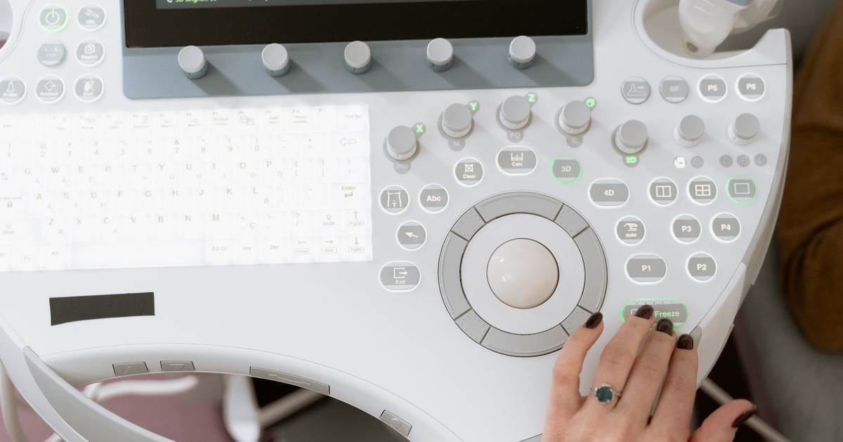 Close-up of a medical professional operating modern ultrasound equipment for diagnosis.