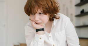 Nearly 40% of Kids With Autism Are Missing This Key Nutrient A young boy with freckles in deep concentration, wearing a white shirt.
