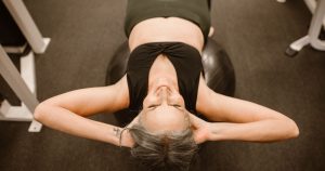 8 Surprising Things You Didn't Know About Menopause Senior woman performing exercise on stability ball for fitness and strength.