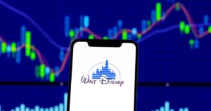 Disney's $50M Settlement Is Paying Out — Here's How To Claim Your Share Hong Kong, China - 28 December 2018: Walt Disney logo is seen on an smartphone over stock chart