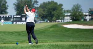 Trump's Golf Tab Hit $101M — Here's What That Looks Like for Struggling Americans BEDMINSTER,NJ-August 9, 2023: Former President Trump (at the time) watches his shot from the18th Tee at the start of the LIV Pro-Am held at the Trump National Golf Club in Bedminster, NJ.