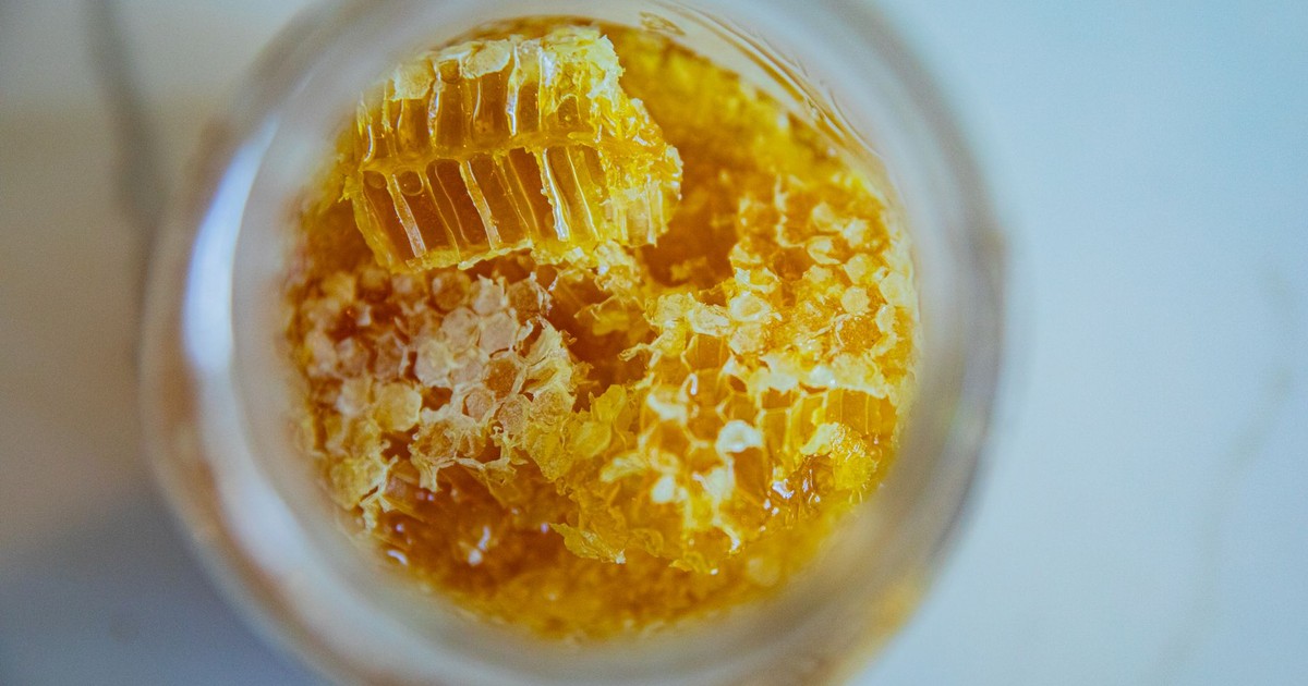 Close-up view of fresh honeycomb pieces in a jar, showcasing natural sweetness and texture.