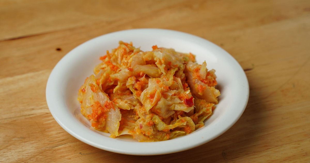 Savory Korean kimchi served in a classic white ceramic bowl on a wooden table.
