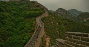 A breathtaking view of the Great Wall of China winding through lush green mountains.