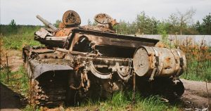 Rusted and damaged tank abandoned in Bucha, Ukraine, symbolizing conflict impact.