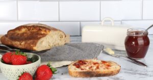 Land O'Lakes Finally Answers: How Long Can Butter Really Sit Out? Sliced bread with strawberry jam, fresh strawberries, and butter on a kitchen counter.
