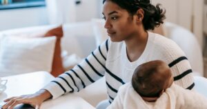 How Much One Parent Needs to Earn so the Other Can Stay Home by State Ethnic baby on laps hugging female in casual outfit with netbook at table while sitting in chair at light apartment near sofa
