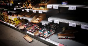 List of Foods Most at Risk as Supermarket Shortages Loom High angle of empty and full shelves in supermarket with price tags and cardboard boxes