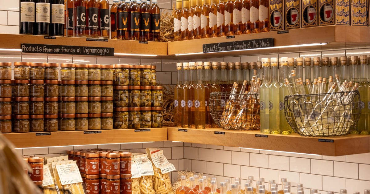 A vibrant display of Italian wines, spirits, and gourmet products in a rustic store setting.