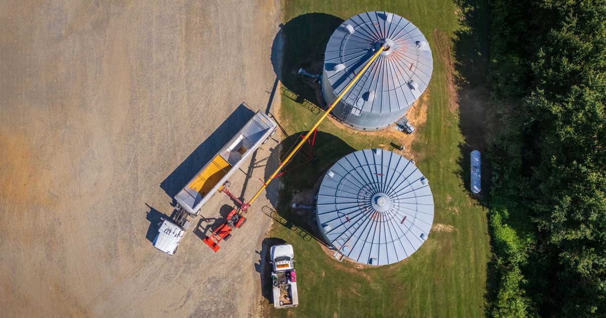 Overhead shot of silos and machinery in a rural setting, highlighting farming operations.
