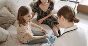 Why Type 2 Diabetes Is Rising Twice as Fast in Young Women A healthcare provider assists a child with a diabetes check-up at home.
