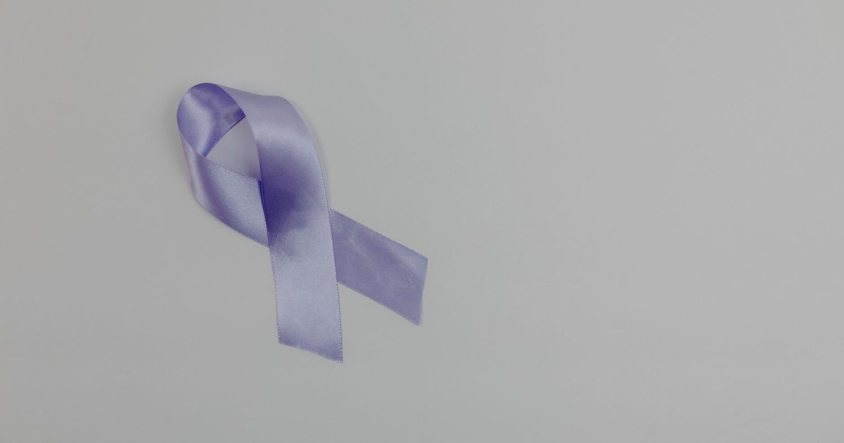 Lavender ribbon representing cancer awareness and support for people with disease placed on white background with copy space in light studio