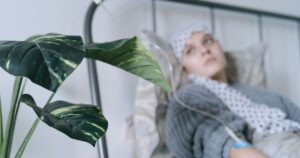 A cancer patient with an IV drip lies on a hospital bed, reflecting hope and recovery.