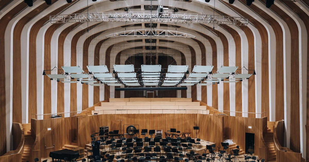 Spacious modern auditorium featuring wooden interior architecture and empty seating.