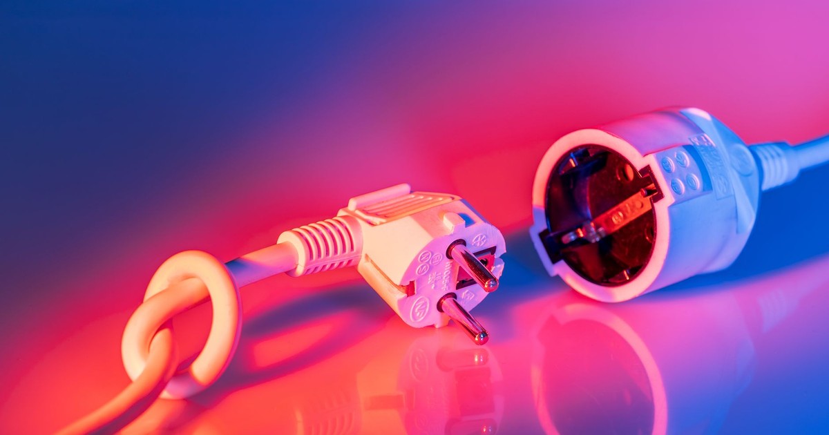 Close-up of electric plug and socket with vibrant lighting, showcasing technology and energy concepts.