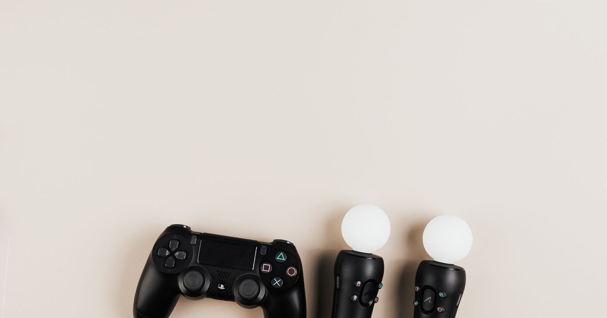 Black gaming controllers arranged on a light background with ample copy space.