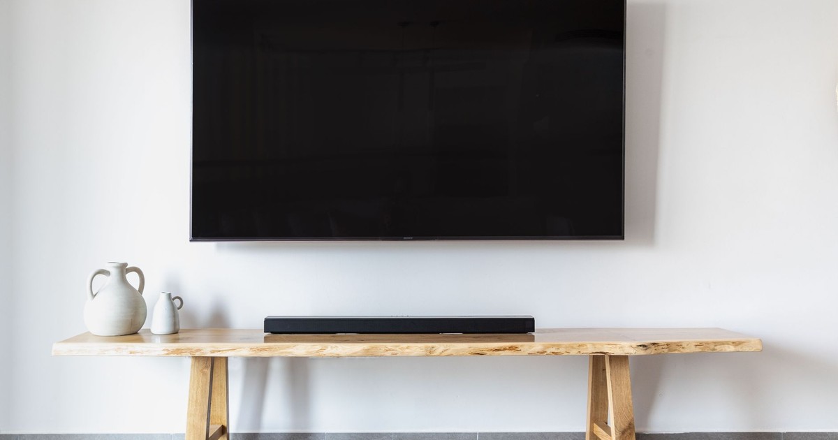 Stylish minimalist living room featuring a wall-mounted flat screen TV and wooden console.