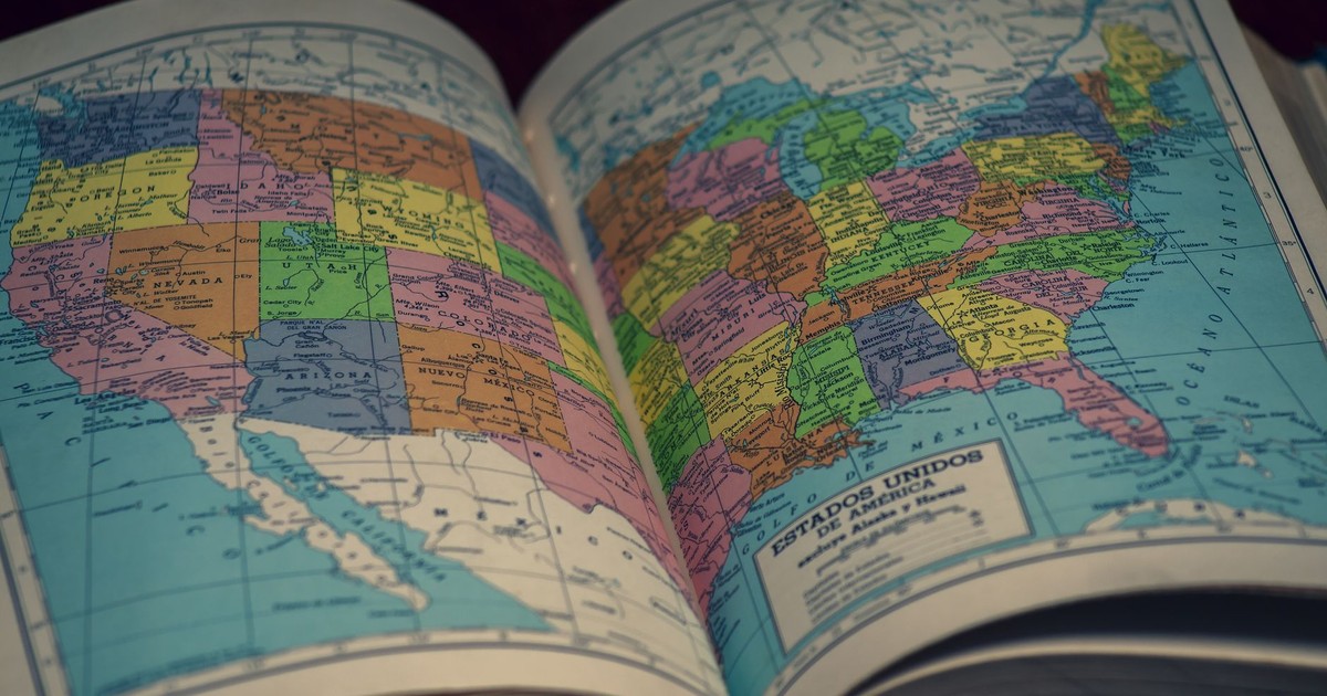 Open atlas showing a colorful map of the United States, highlighting states with vibrant colors.