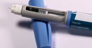 Detailed view of a semaglutide injection pen, commonly used for diabetes treatment, on a plain background.