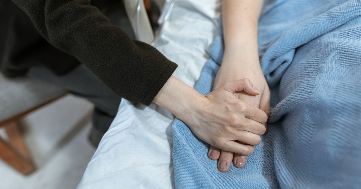 A comforting hand hold in a hospital, showcasing support and care.
