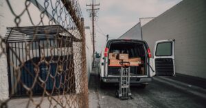 An open van loaded with boxes in an alley, ready for donation deliveries.