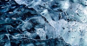 Antarctica's Gold-Spewing Volcano Is Real — And Scientists Still Don't Know How It Works Detailed close-up of textured ice in Antarctica, showcasing intricate frozen patterns.