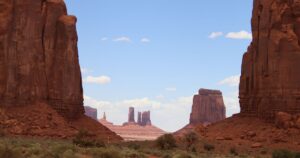 Trump Just Slashed Two Sacred Utah Monuments by 90%. Here's What's at Stake. Breathtaking view of towering red rock formations in Monument Valley under a clear blue sky.