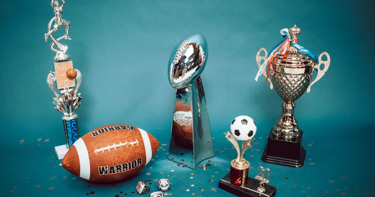 A collection of sports trophies and memorabilia representing achievement and success on a blue background.