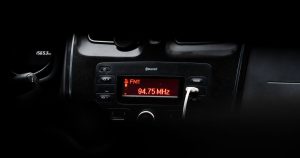 A detailed image of a car's dashboard showing a radio display with red LED lights.